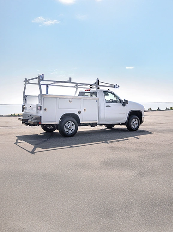 upfitted work truck in white parked next to a body of water